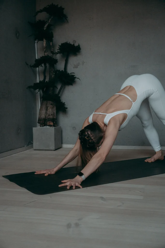a woman in white yoga outfit stretching on a mat